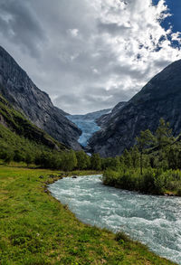 Scenic view of river amidst mountains against sky