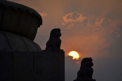 Silhouette of statue against sky during sunset