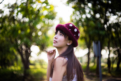 Young woman standing against tree