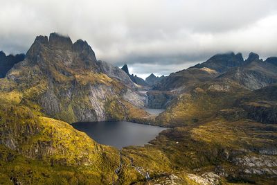 Scenic view of lake and mountains against cloudy sky