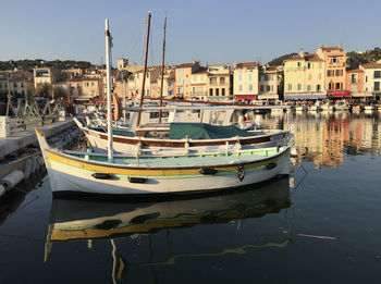 Boats moored at harbor against buildings in city