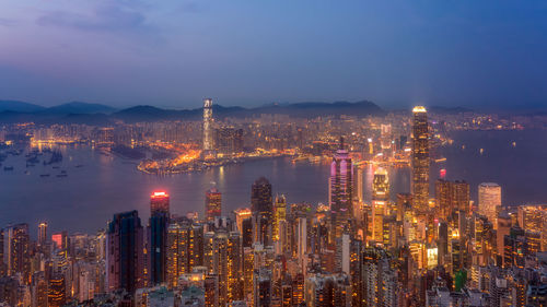 Illuminated cityscape against sky at night