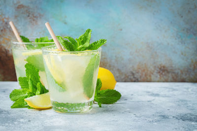 Two glass with lemonade or mojito cocktail with lemon and mint, cold refreshing drink.