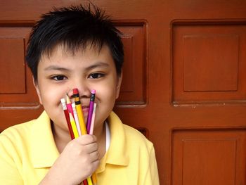 Close-up of young holding pencils