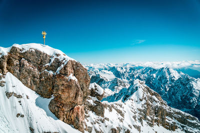 Panoramic view of snowcapped mountains against blue sky