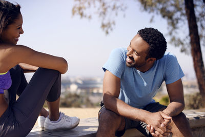 Happy couple sitting on rocks at countryside