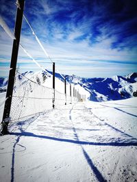 Scenic view of snow covered mountain against blue sky