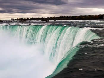 Scenic view of waterfall against sky
