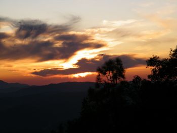 Scenic view of silhouette mountains against orange sky