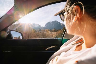 Portrait of woman in car during winter with sunbeam