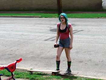 Full length portrait of woman standing on road