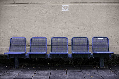 Metallic blue chairs against wall