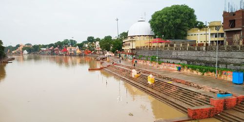 Panoramic view of canal by city against sky