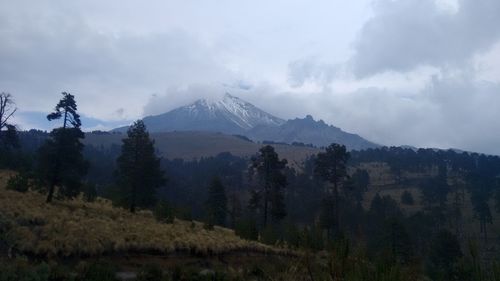 Scenic view of mountains against cloudy sky