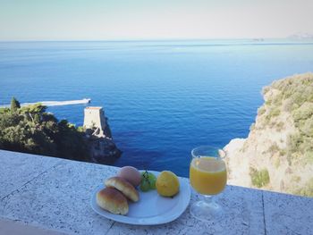 High angle view of breakfast on table by sea against sky