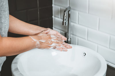 Midsection of person in bathroom at home