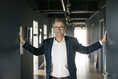 Portrait of mature businessman standing on office floor