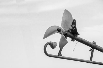 Low angle view of a bird on metal against sky