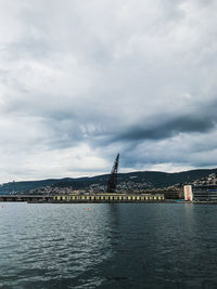 View of bridge over sea against cloudy sky