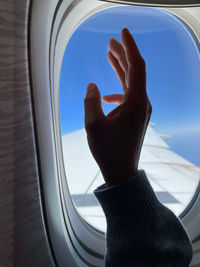 Female hand against the airplane window