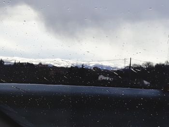 Raindrops on road seen through wet window