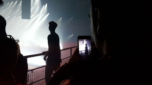 Low angle view of silhouette people against illuminated sky at night