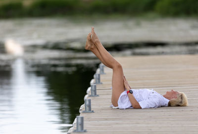 Rear view of woman sitting on pier