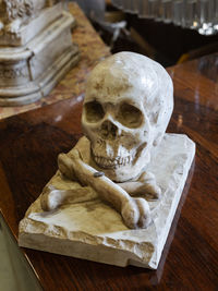 Human skull ornament leaning on a wooden cabinet.