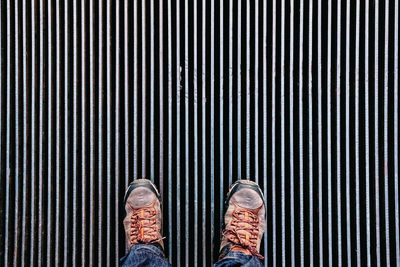 Low section of man standing on metal