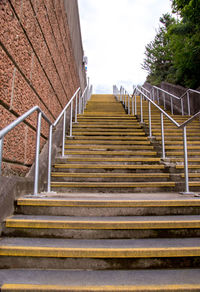 Low angle view of staircase by building against sky