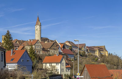 Buildings in town against blue sky