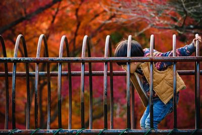 Side view of boy standing in playground during autumn