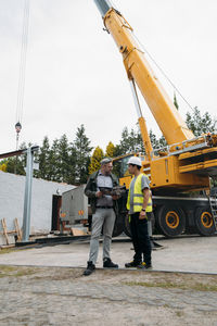 Foreman and customer or client agree about future building work on construction site. man looking in