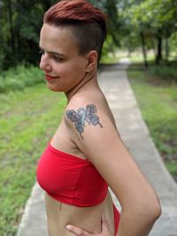 Side view of young woman standing at park