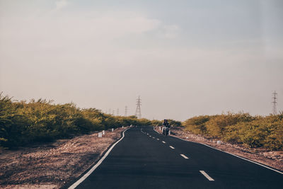 Road amidst trees against sky