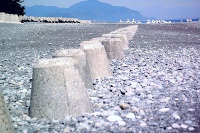 Surface level of stones on beach against sky