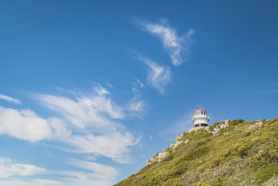 Low angle view of lighthouse on mountain against sky