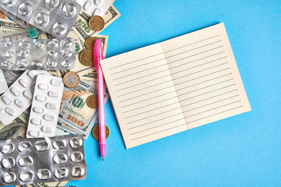 High angle view of pen on paper against blue background