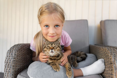 Portrait of cute girl with cat outdoors