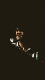 Low angle view of man standing against black background