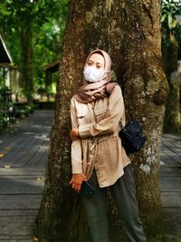 Rear view of woman standing in forest