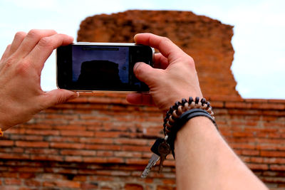 Midsection of man photographing with mobile phone