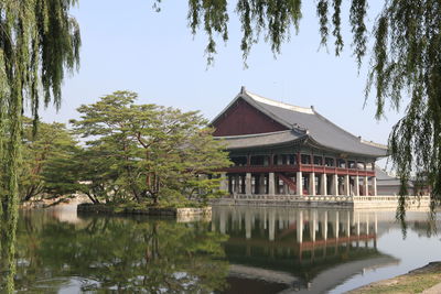 Building by lake against sky