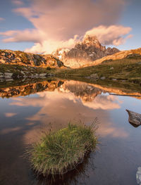 Scenic view of lake by mountains against sky