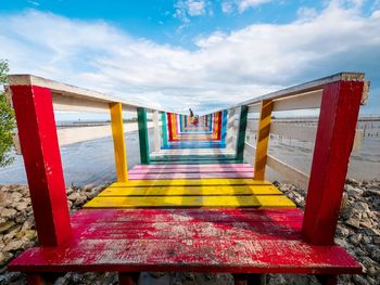 Empty wooden bridge against sky