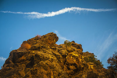 Low angle view of rocky mountain against sky