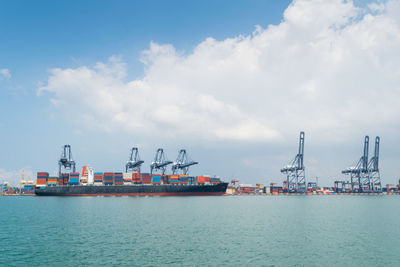 Commercial dock by sea against clear sky