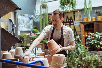 Male mid adult owner arranging terracottas at store