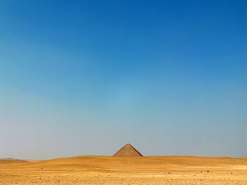 Scenic view of desert against clear blue sky