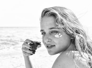 Portrait of mid adult woman at beach against sky